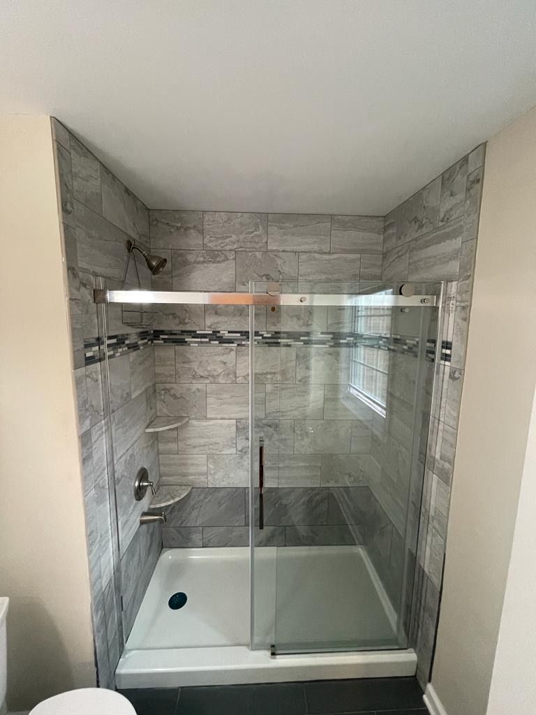 A bathroom with a walk in shower and a toilet.