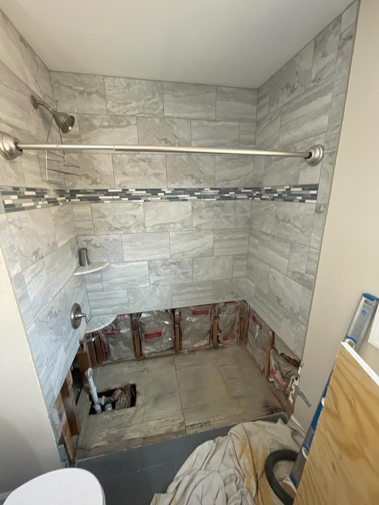 A bathroom with a shower and a toilet under construction.