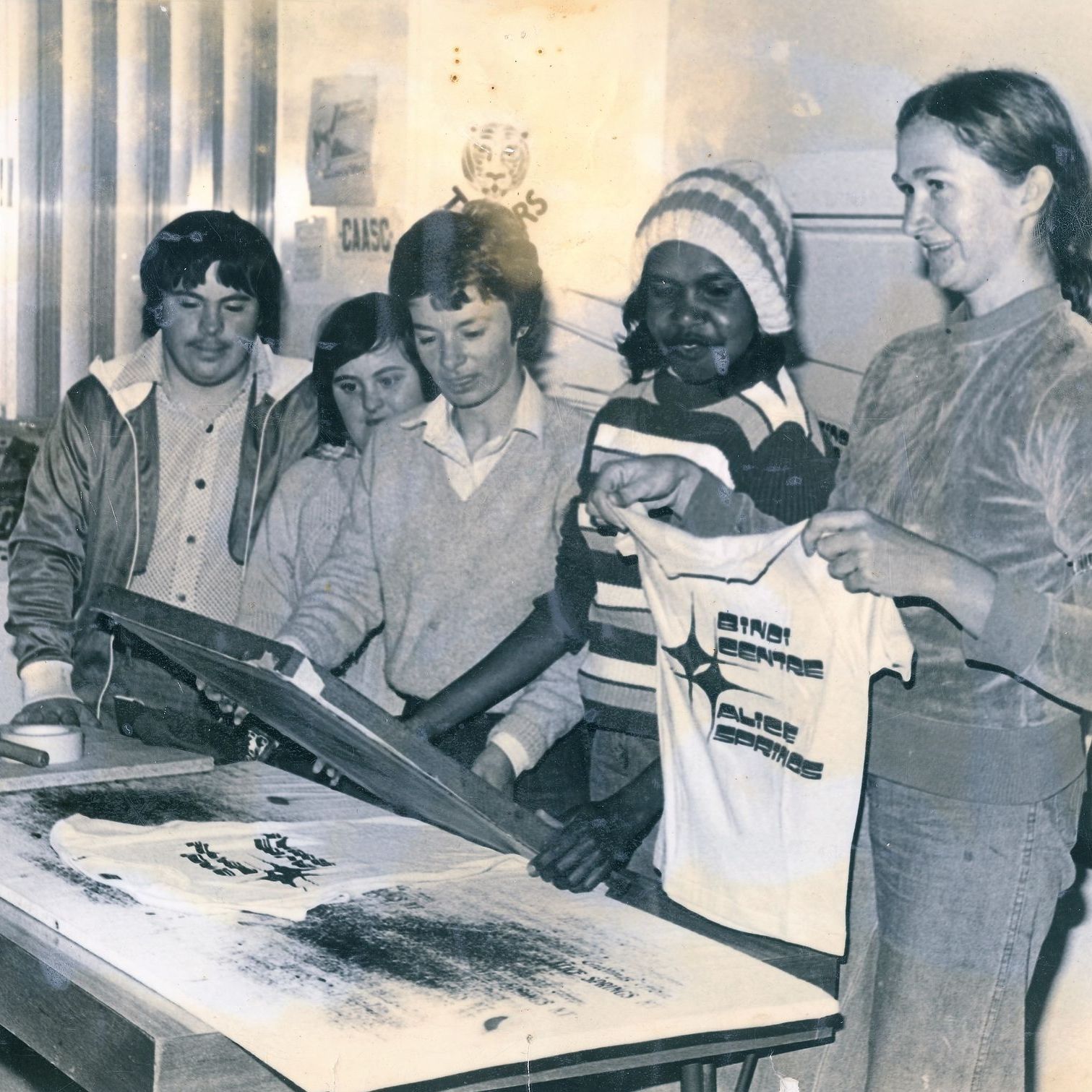 A group of people are standing around a table with a sign that says caasc