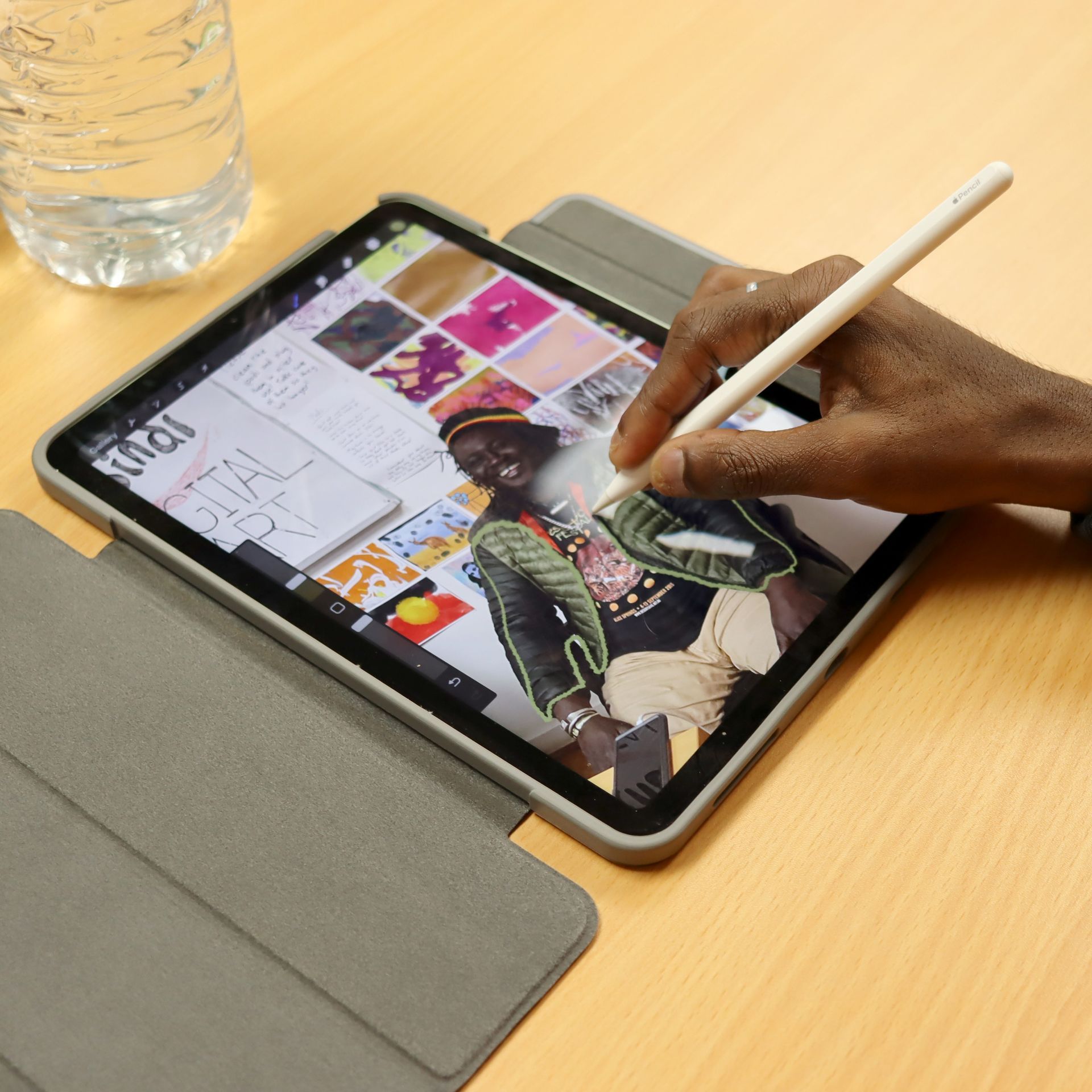 A person is drawing on a tablet that says ipad