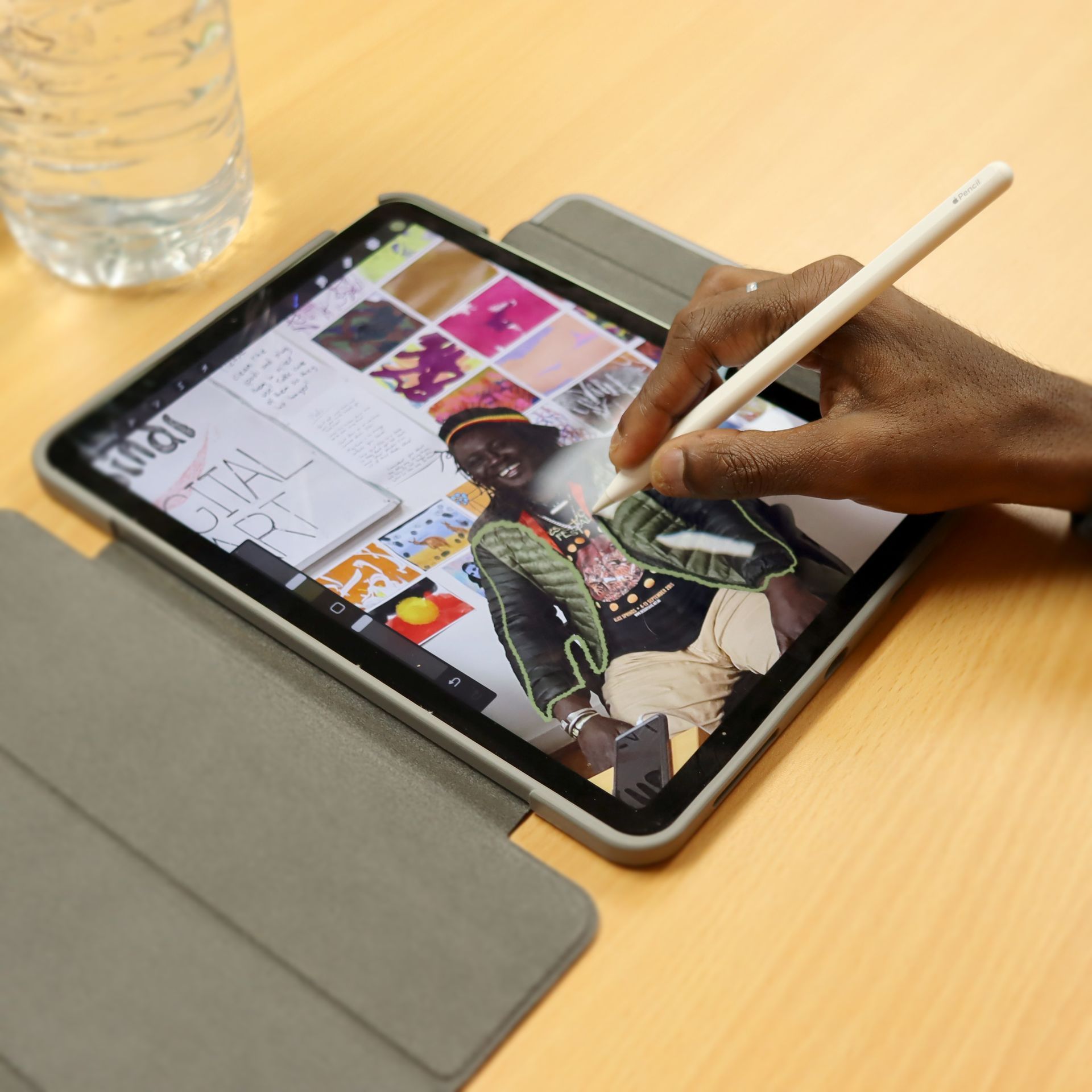 A person is drawing on a tablet that says ipad