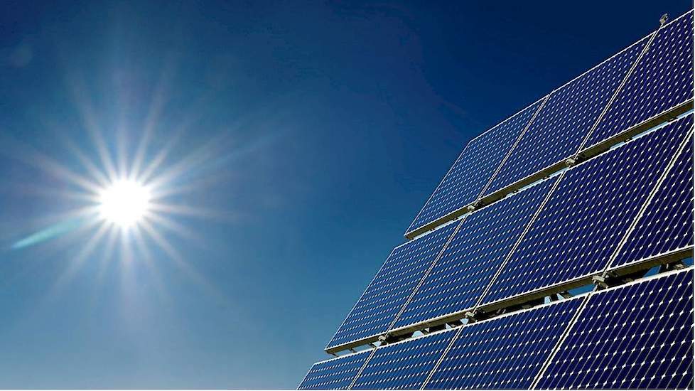 Zonnepanelen gericht naar de zon in een helderblauwe lucht.