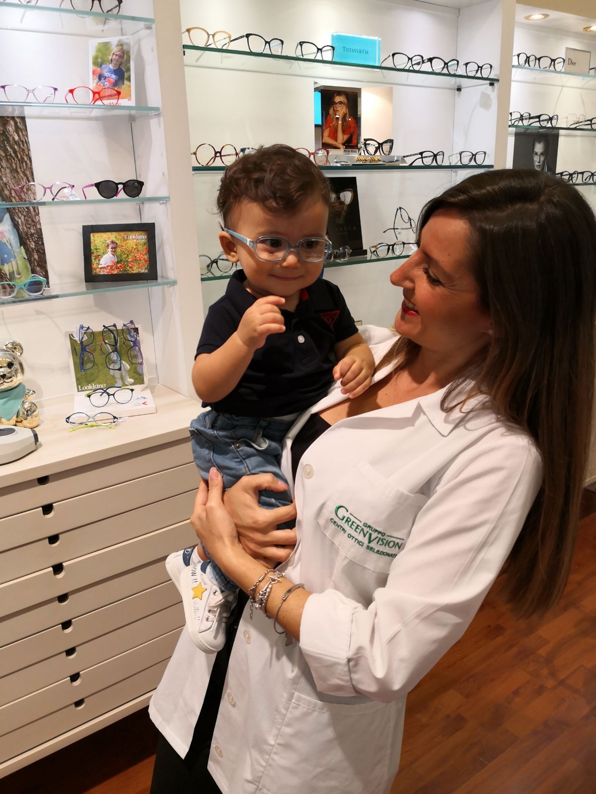 bambino che prova occhiali da vista con optometrista