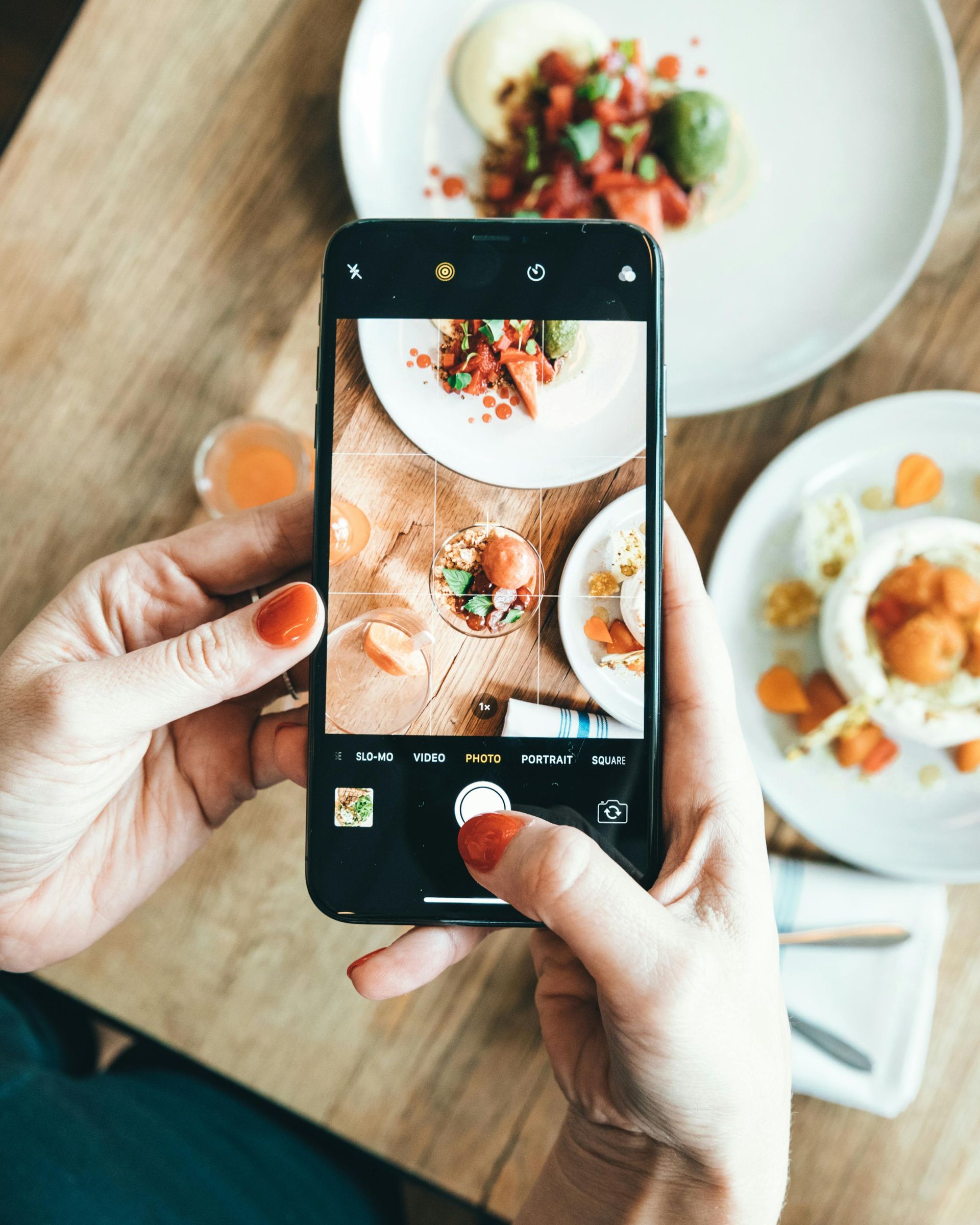 A person is taking a picture of food with a cell phone.