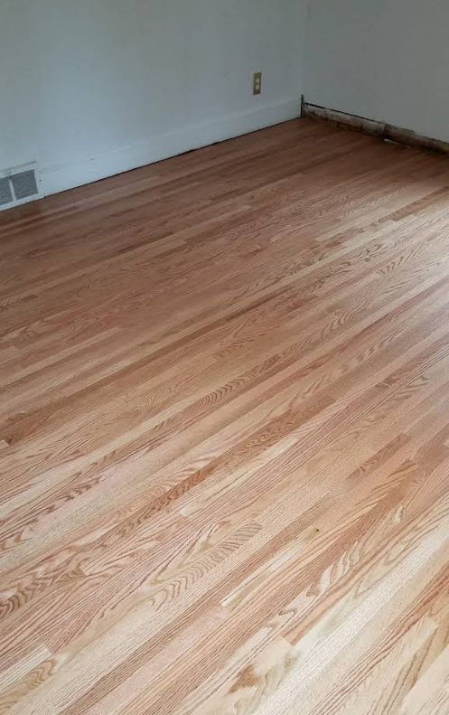 Empty room with light wood flooring and white walls