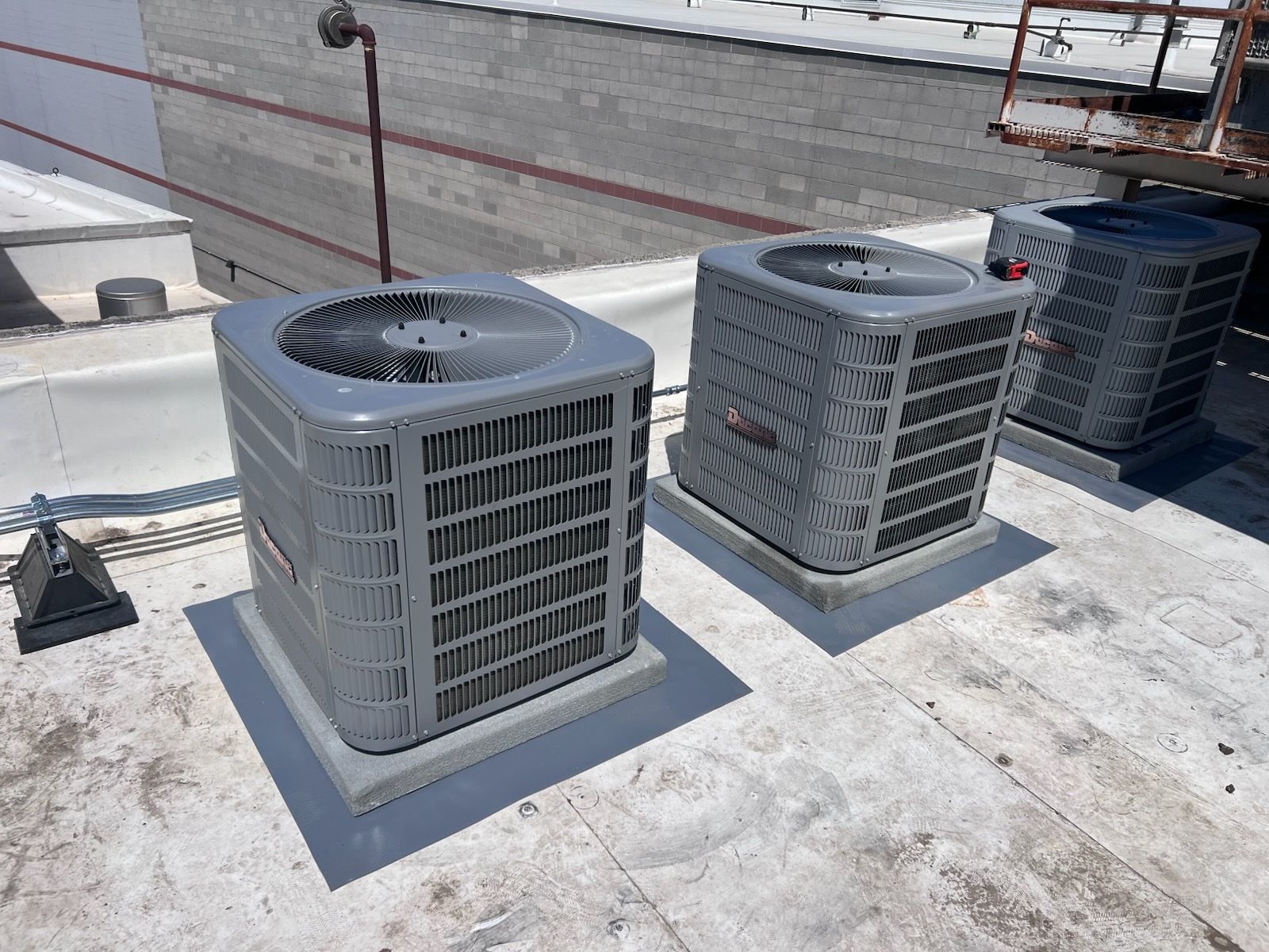 A man is working on an air conditioner outside of a building.