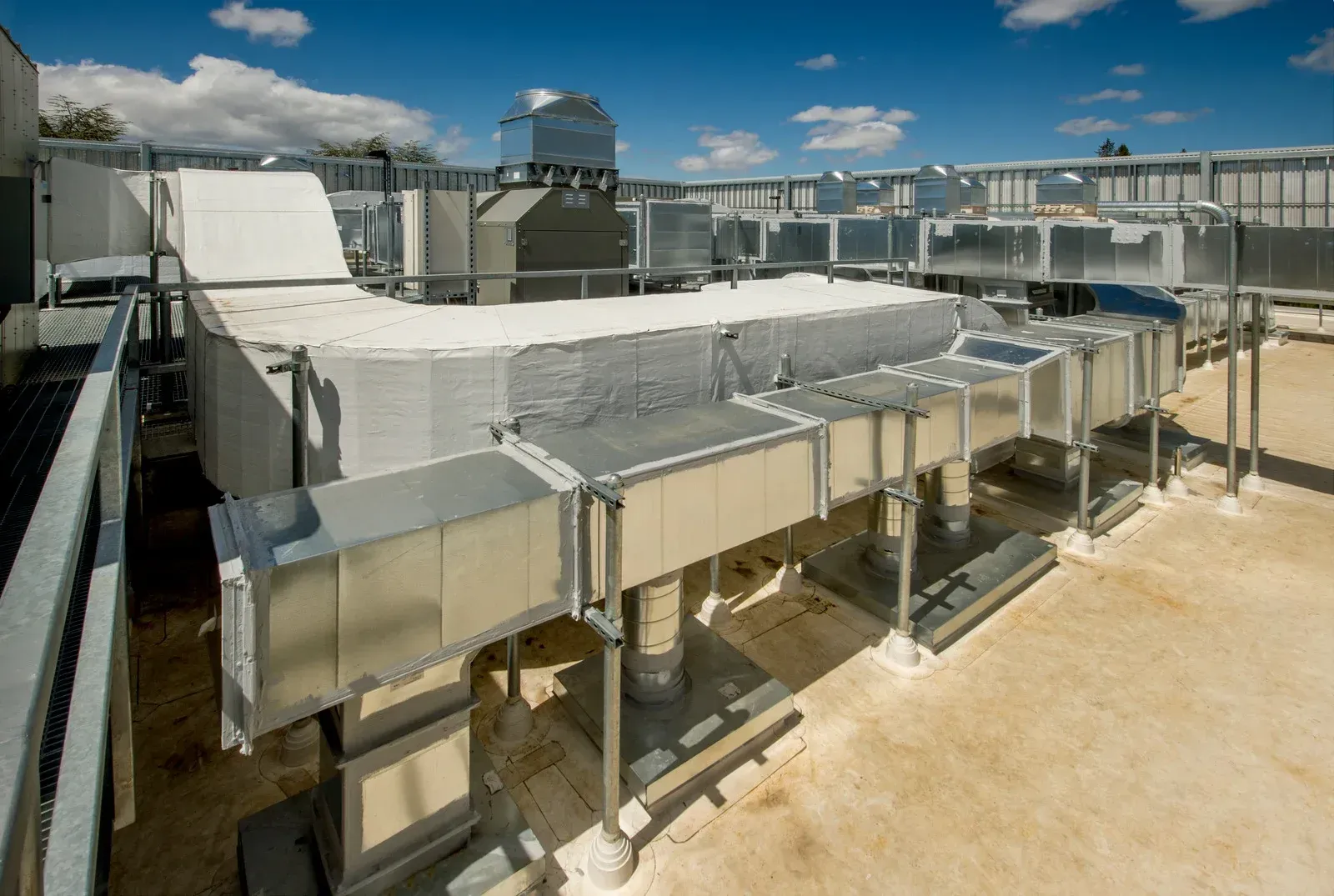 The roof of a building with a lot of pipes going through it.