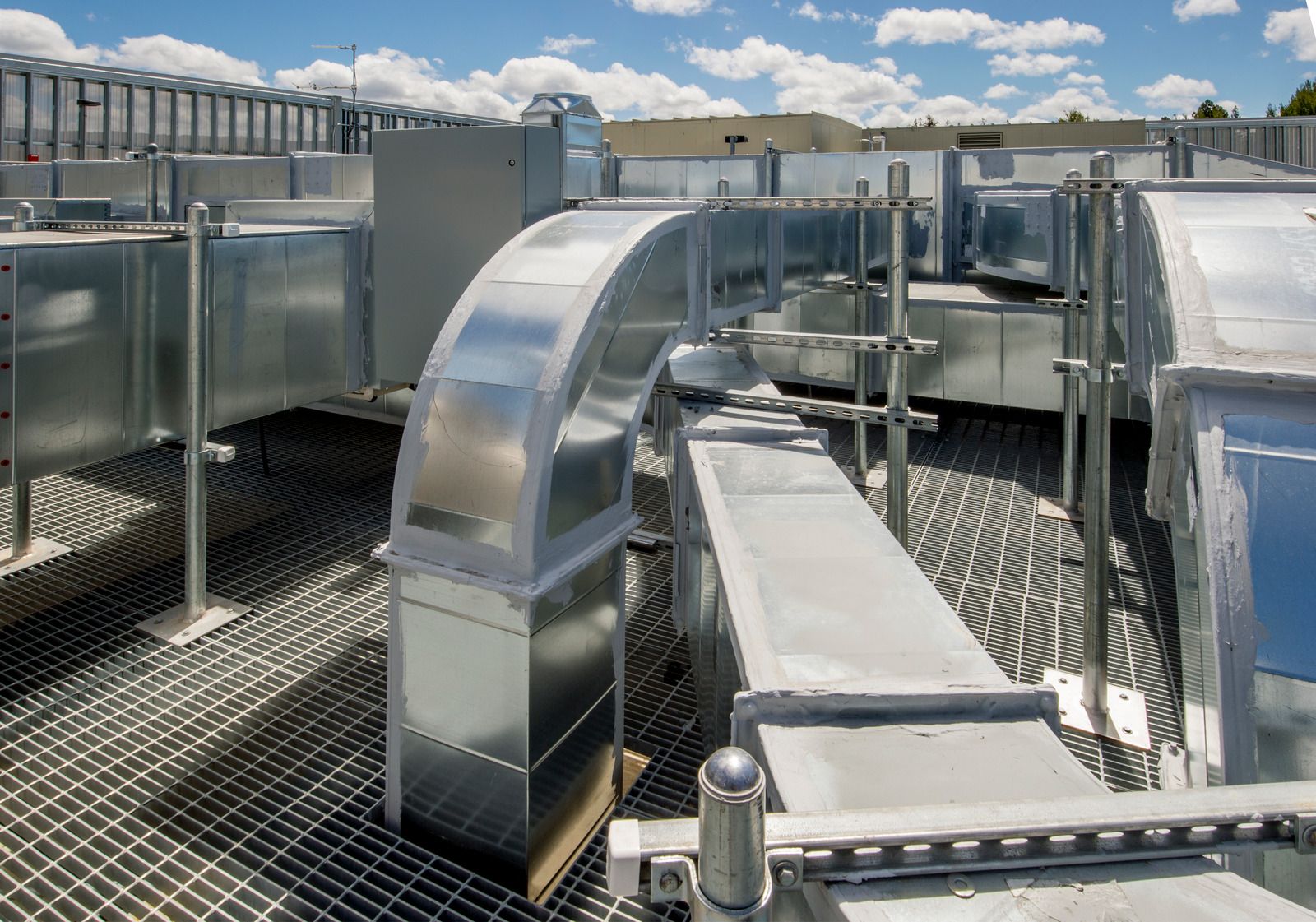 There are a lot of metal pipes on the roof of a building.