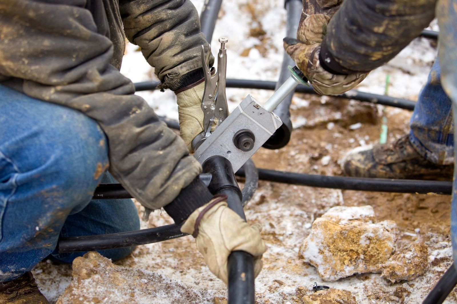 A man is cutting a pipe with a pair of pliers.