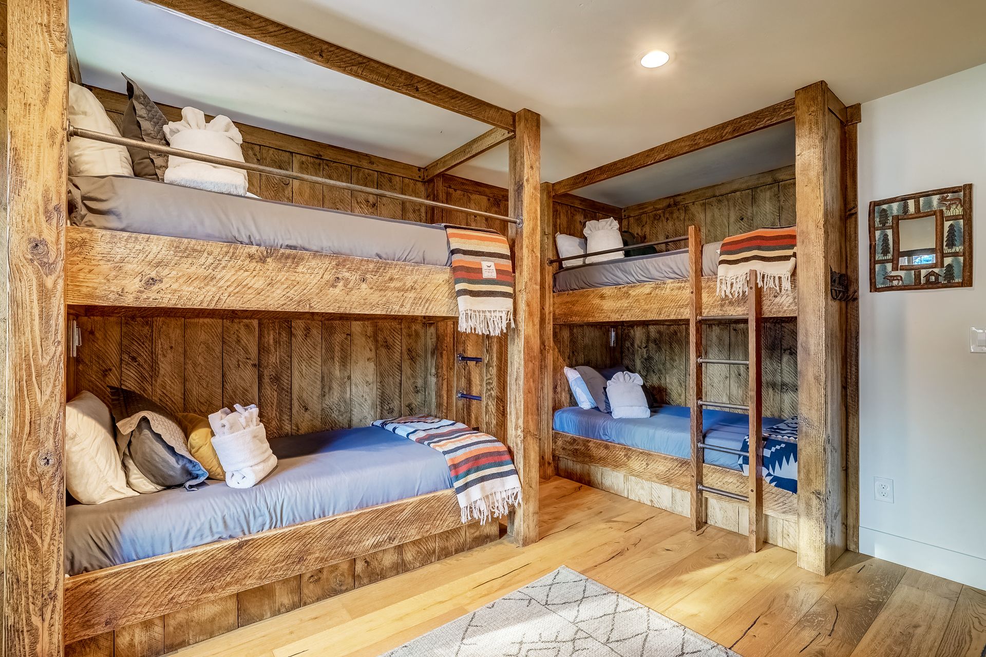 Rustic bunk beds in a cozy bedroom with wood paneling and blue bedding