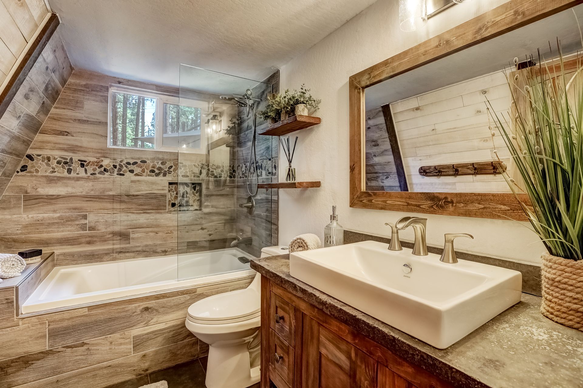 Modern bathroom with a bathtub, walk-in shower, wood vanity, and large mirror