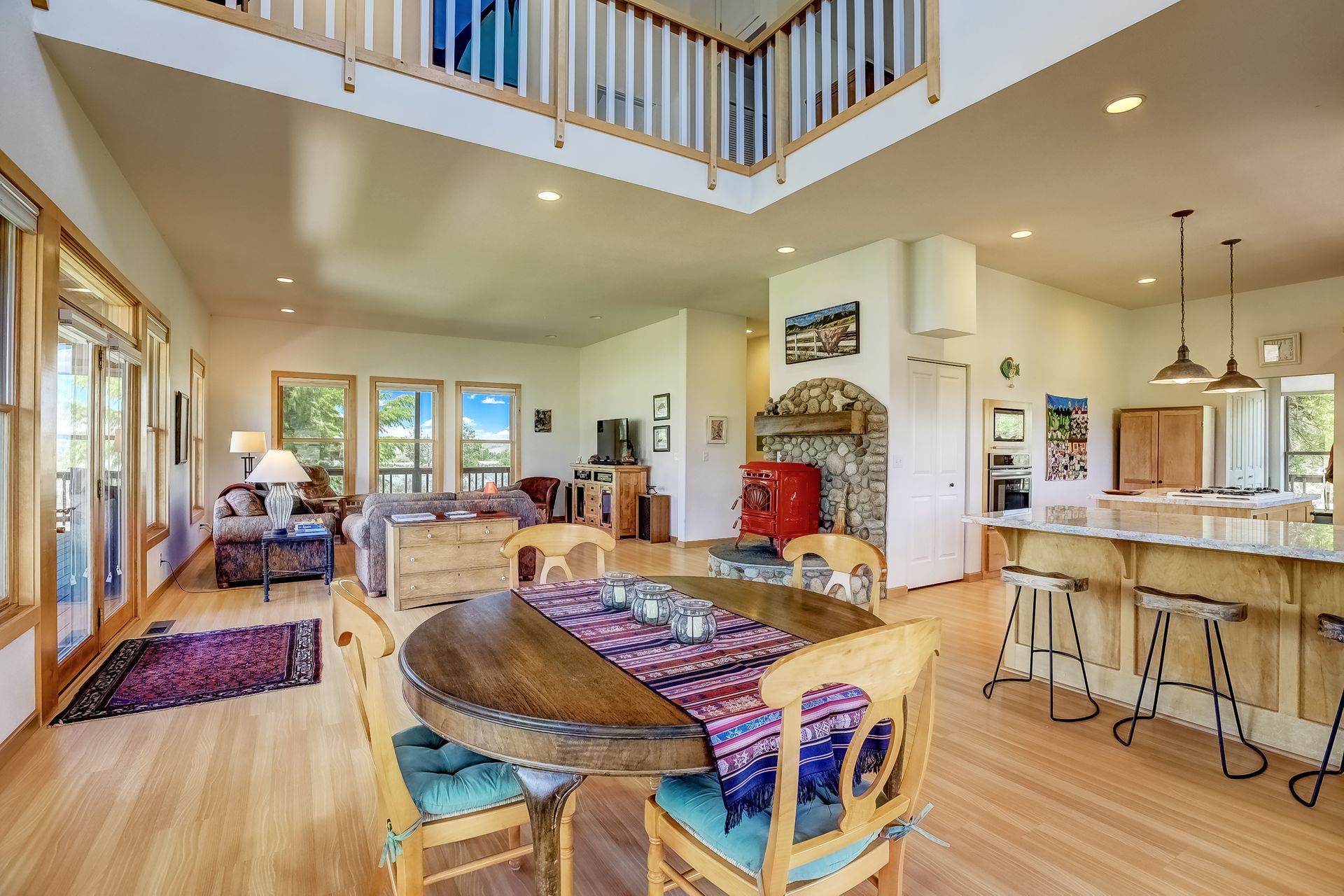 Bright open-concept living room and kitchen with hardwood floors, balcony, and large windows