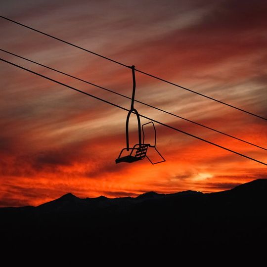Ski chairlift at Heavenly Ski Resort with mountains and sunset in background