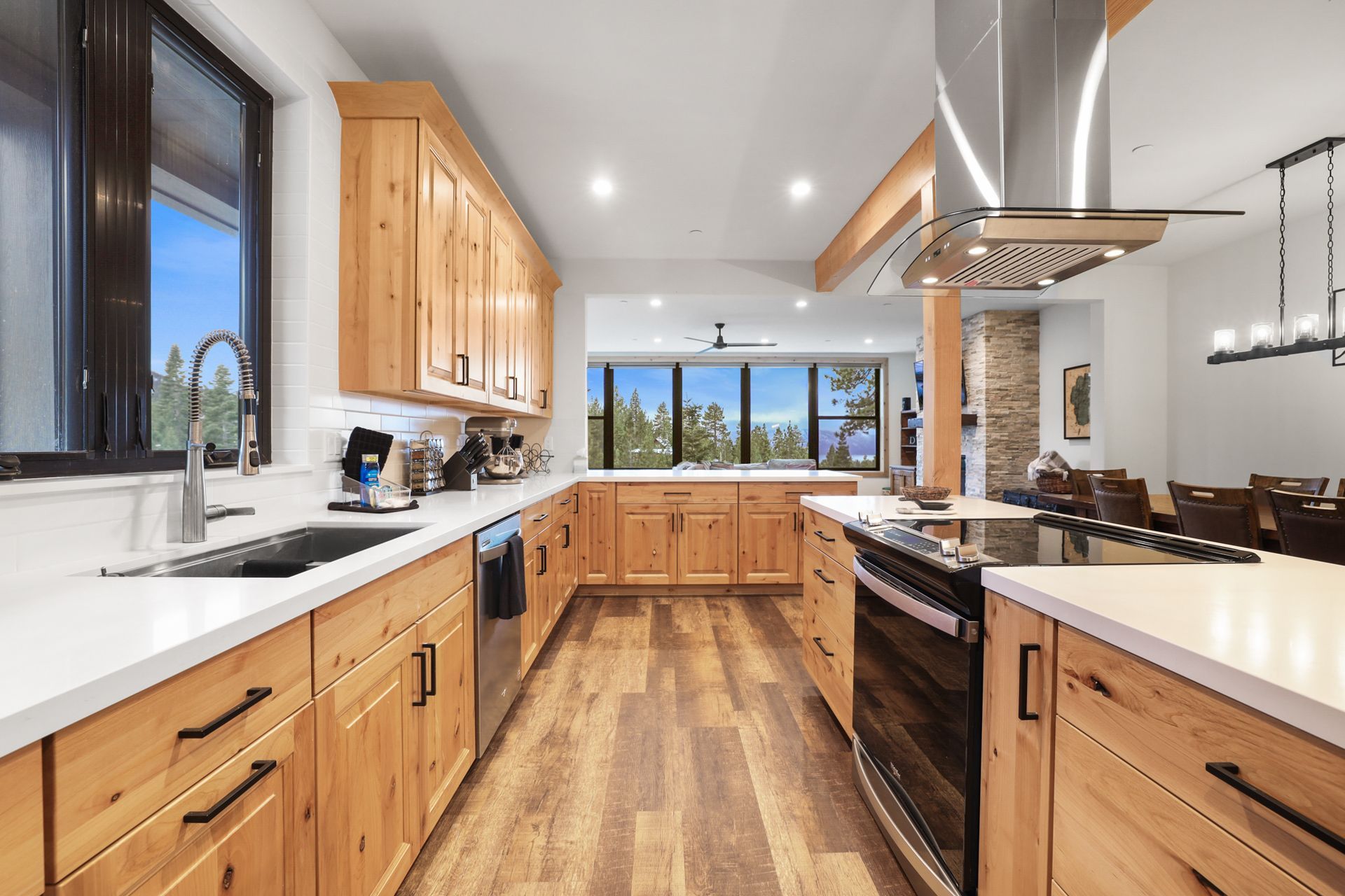 Bright modern kitchen with wood cabinets, white countertops, stainless appliances, and large window view.
