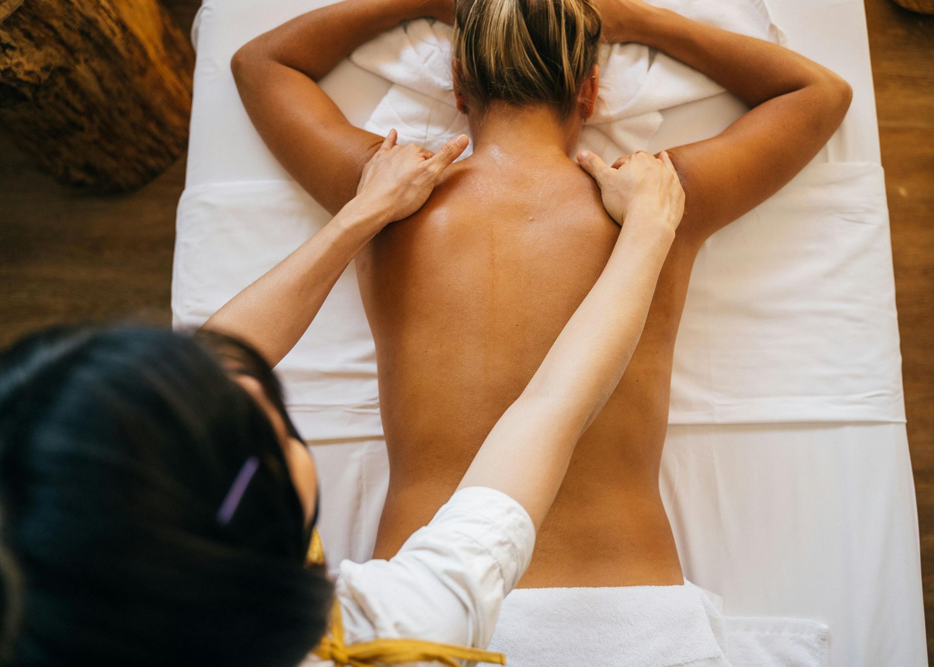 Massage therapist working on a client’s back on a treatment table