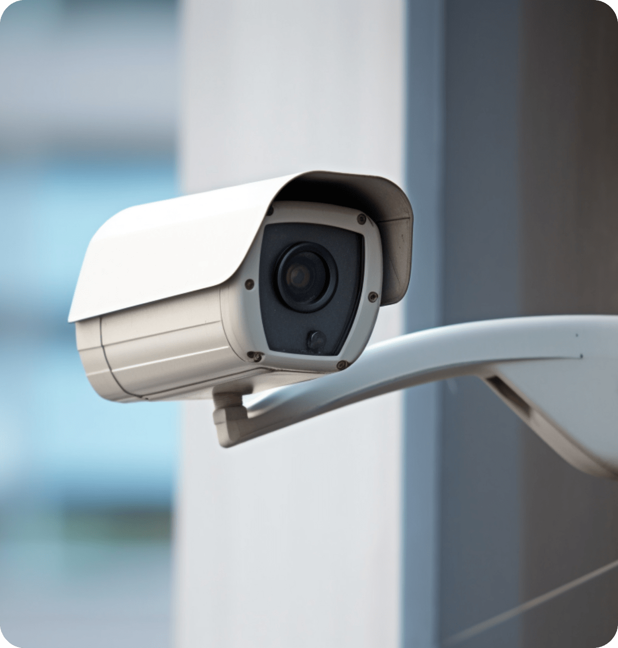 A security camera is mounted on a pole outside of a building