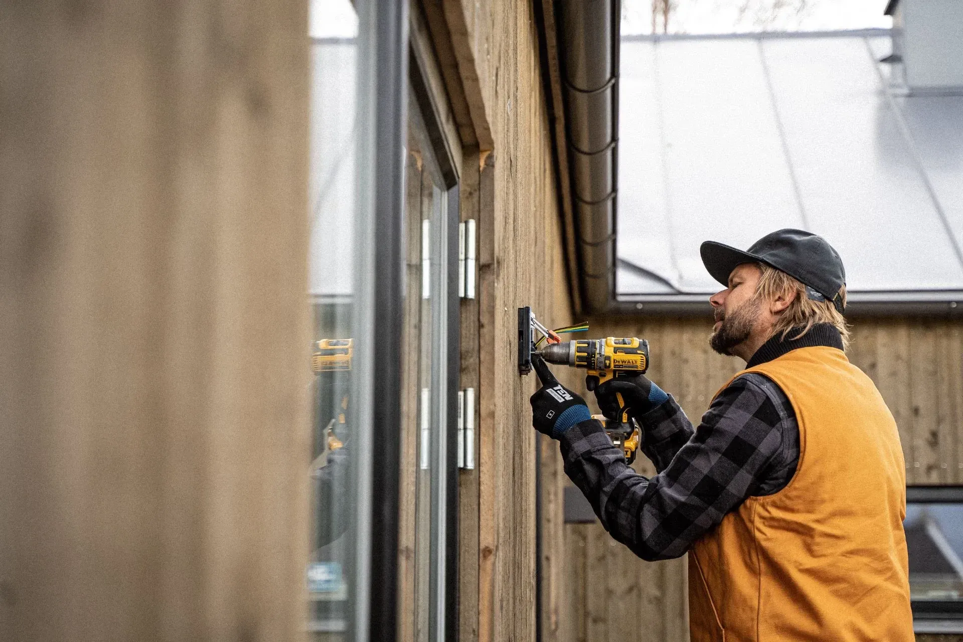 Technician drilling a hole into drywall