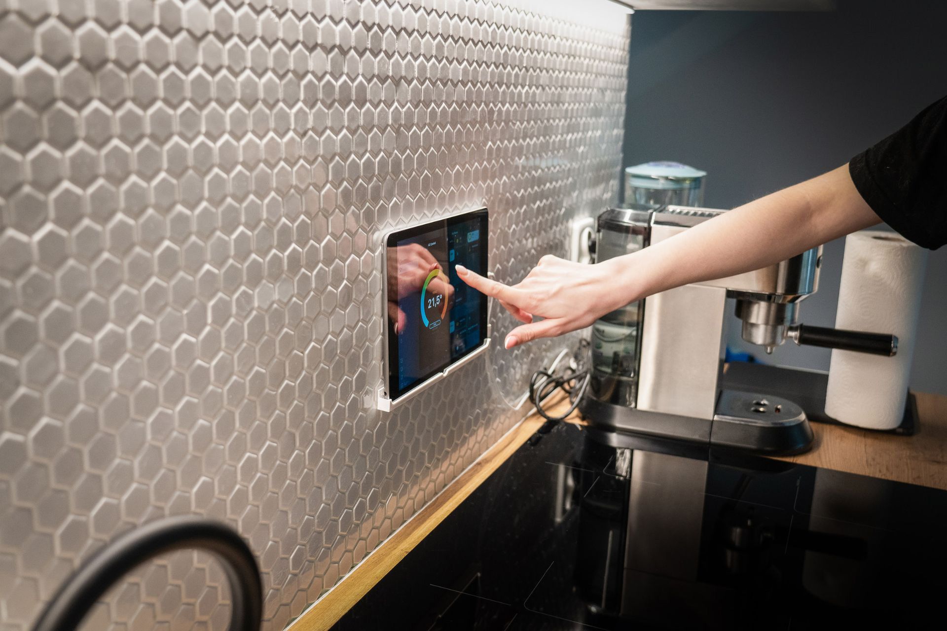 A person adjusting the thermostat through a smart home central control 