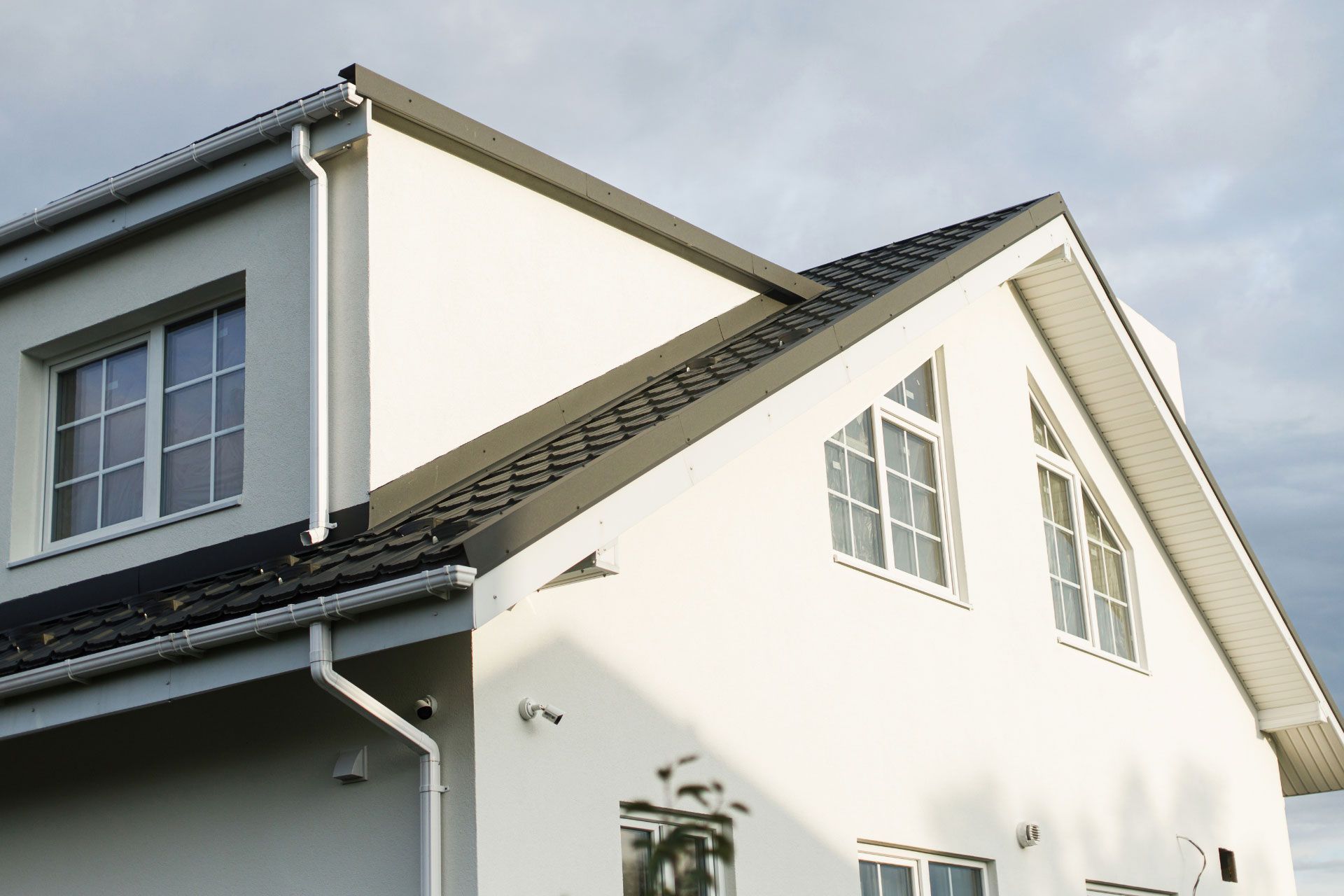 White home with two security cameras on the exterior
