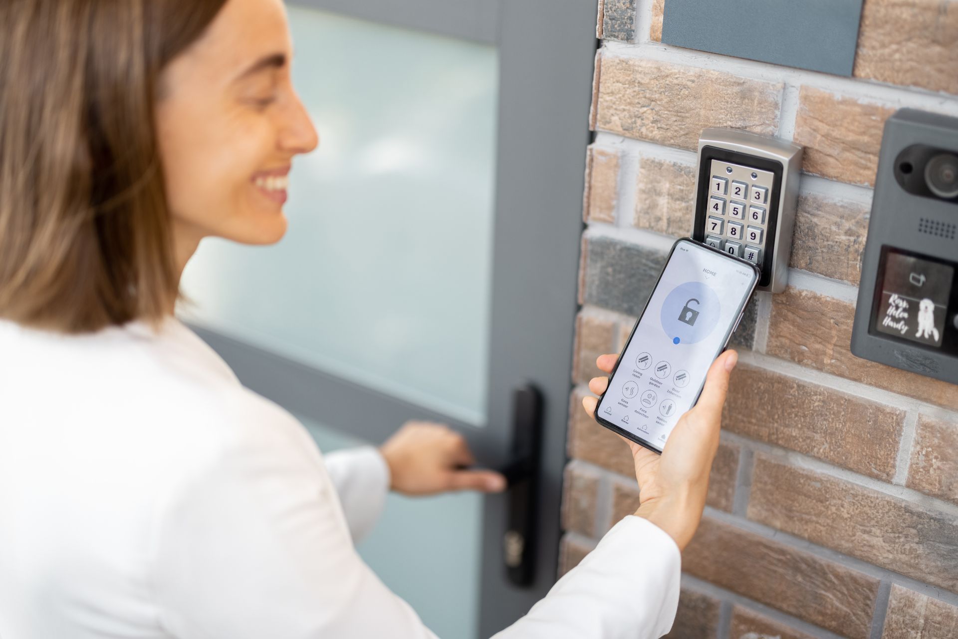 A woman unlocking her home from the outside through her phone’s smart home app