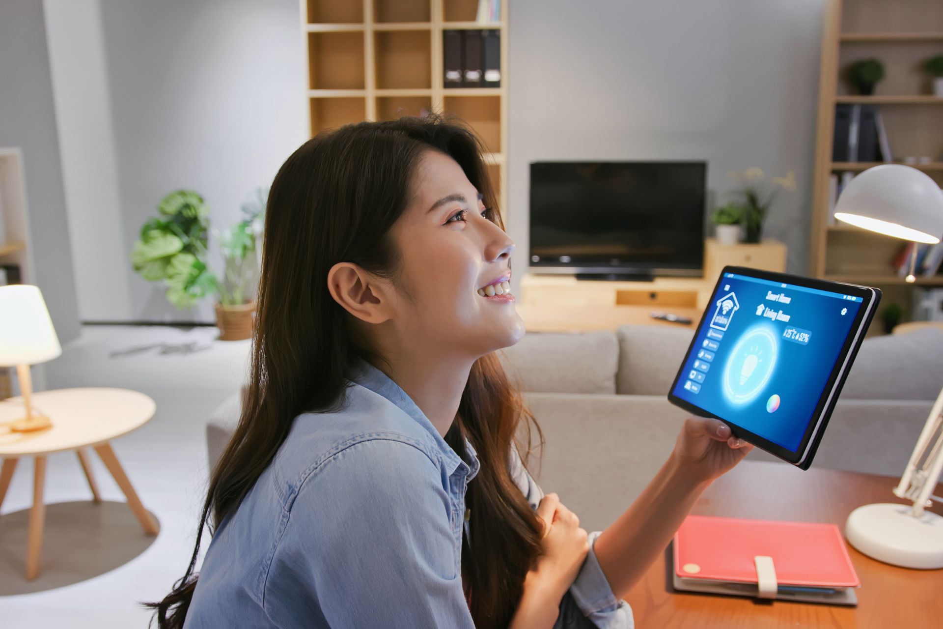 A woman controlling smart home system on a tablet