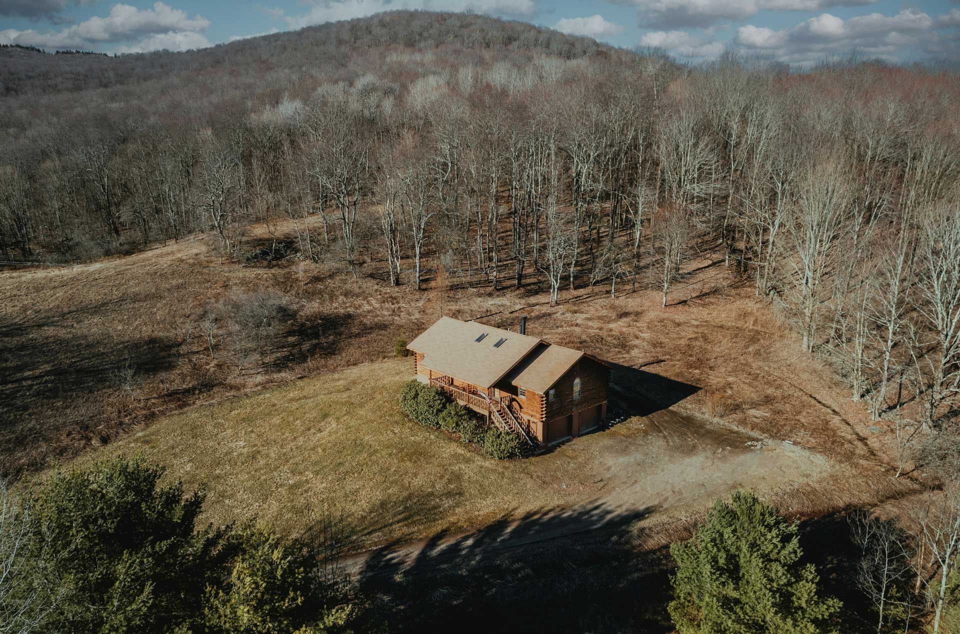 A rural house on a hill surrounded by forest