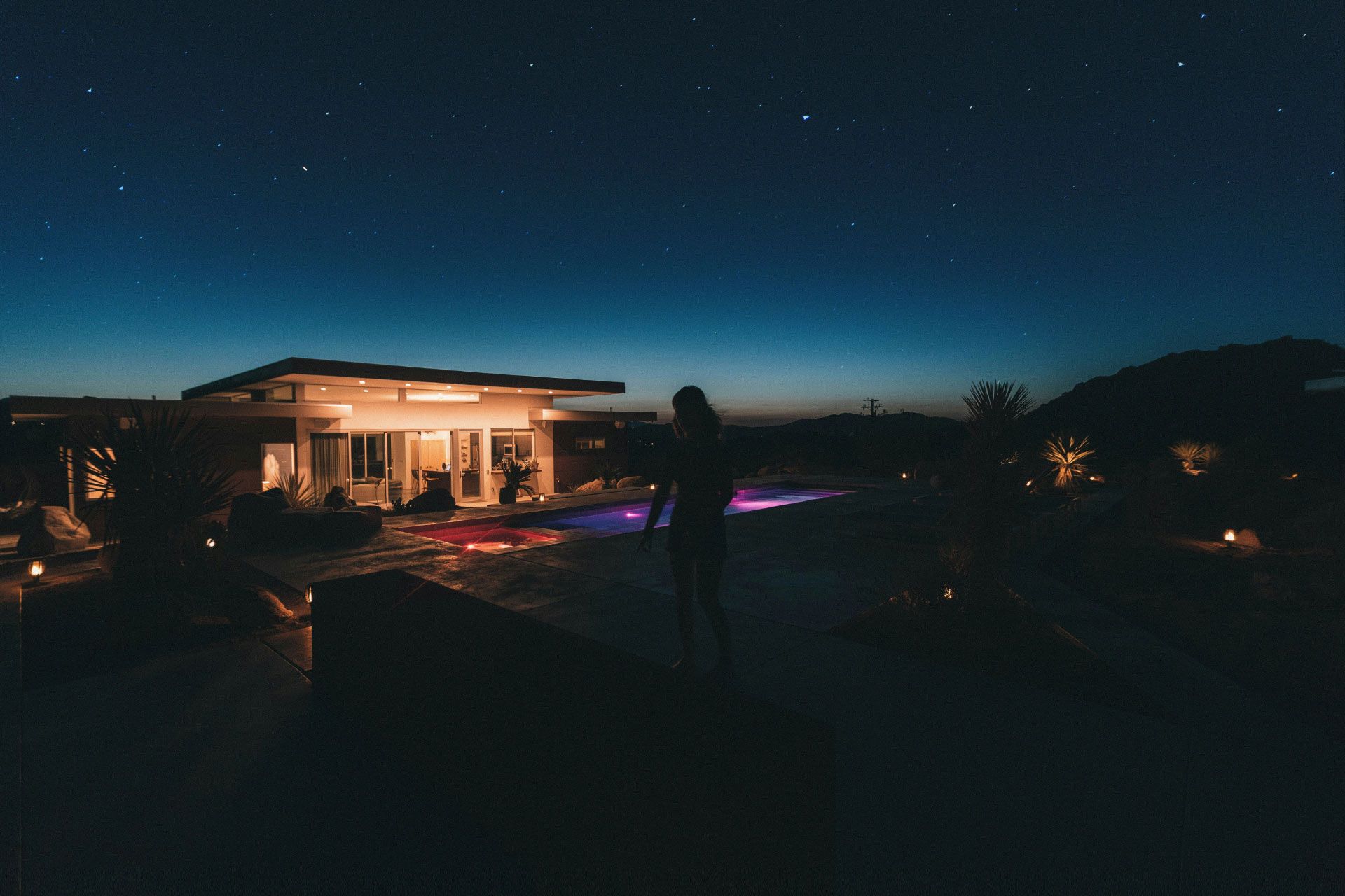 A woman walking through her modern property at night