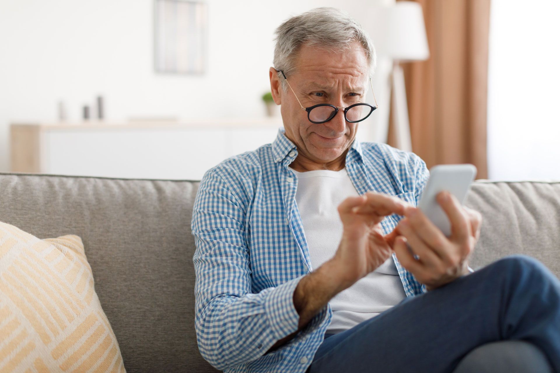 Elderly man using the phone to view security system