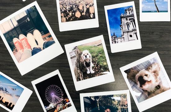 A bunch of polaroid pictures are laying on a table.