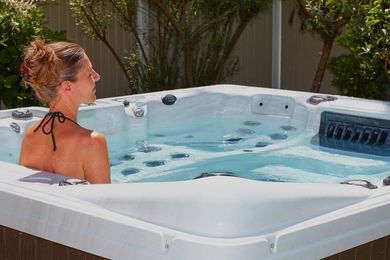 A woman in a bikini is sitting in a hot tub.