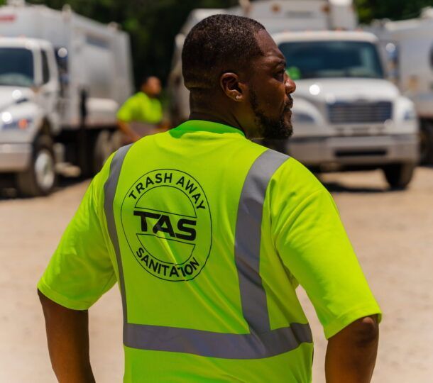A man wearing a neon green shirt that says trash away