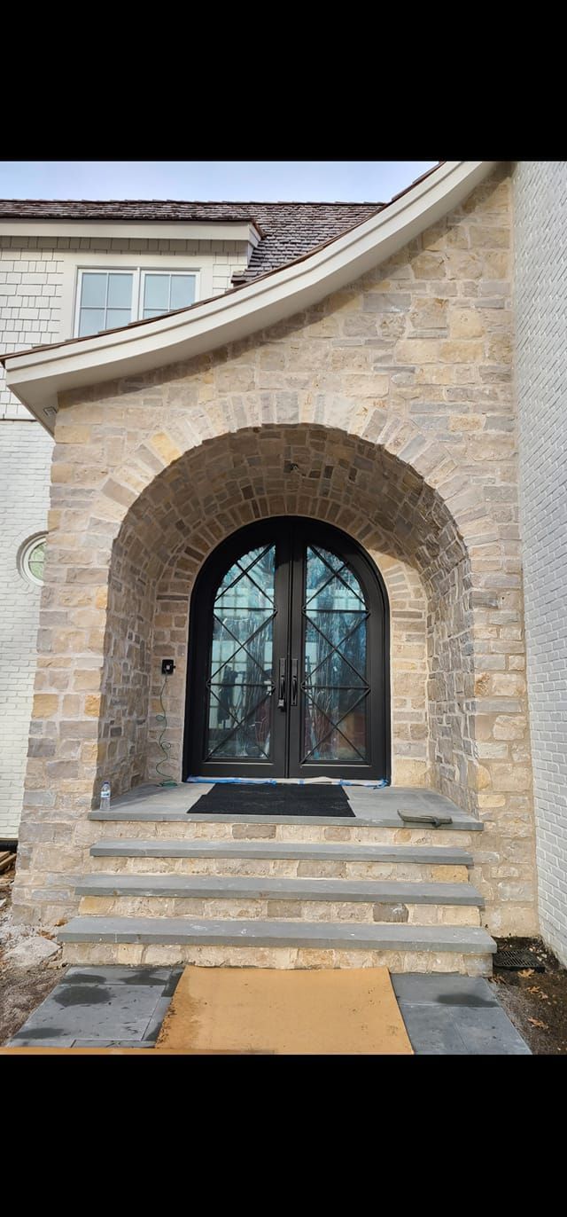 The front door of a house with a stone archway and steps.
