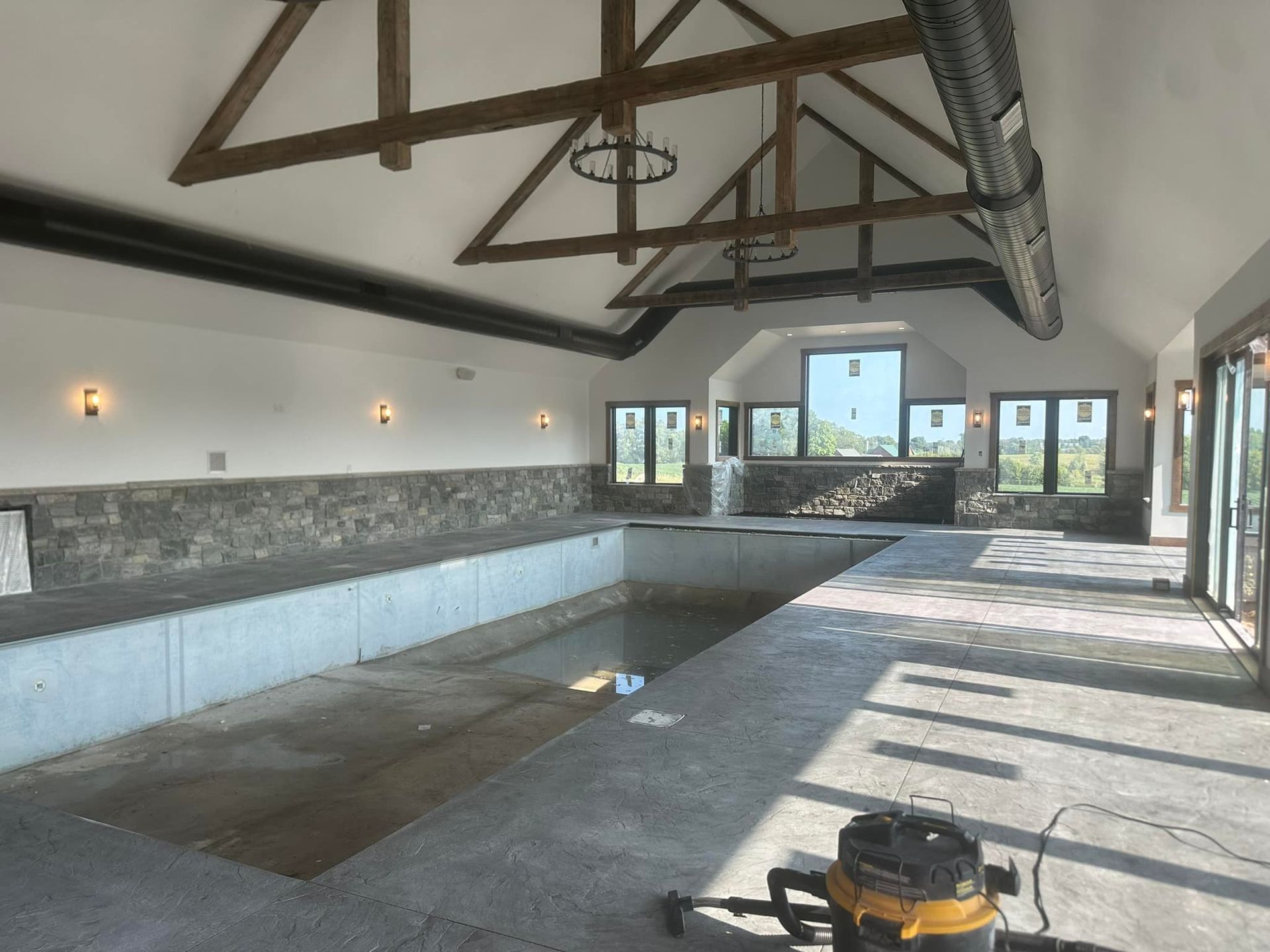 A large room with a swimming pool and a vacuum cleaner on the floor