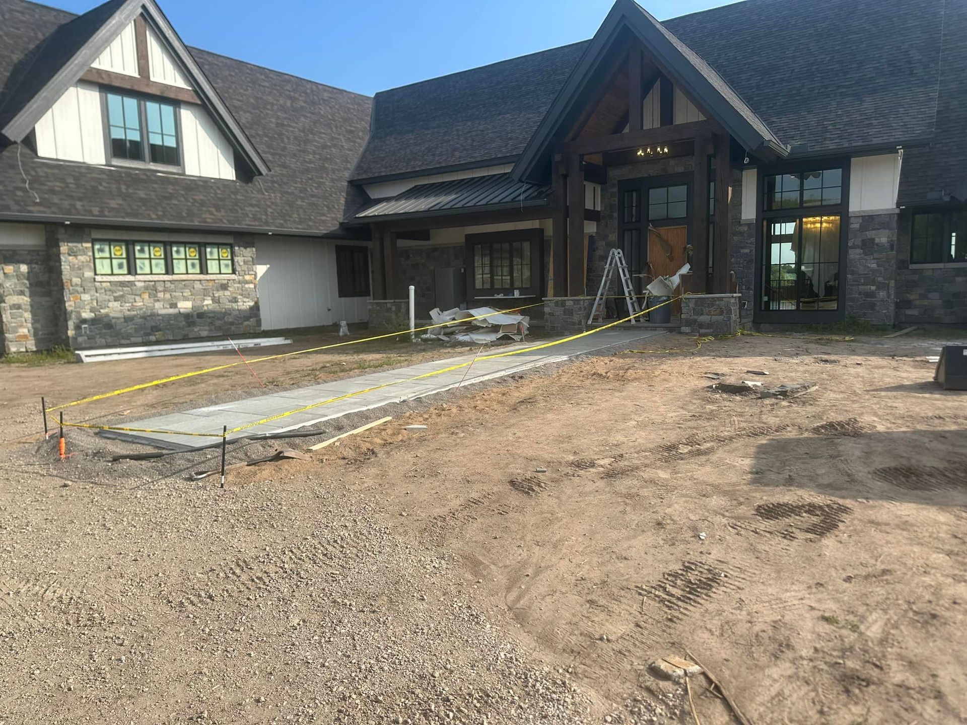 A large house with a gravel driveway in front of it.