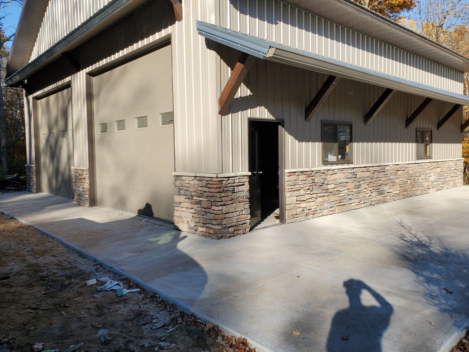 A garage with a concrete driveway in front of it.