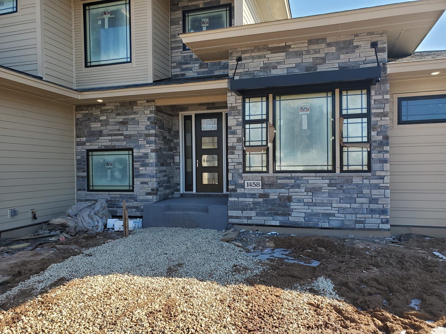 The front of a house with a lot of dirt in front of it.