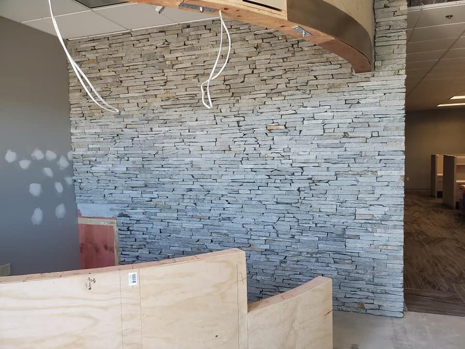 A room with a brick wall and a wooden divider