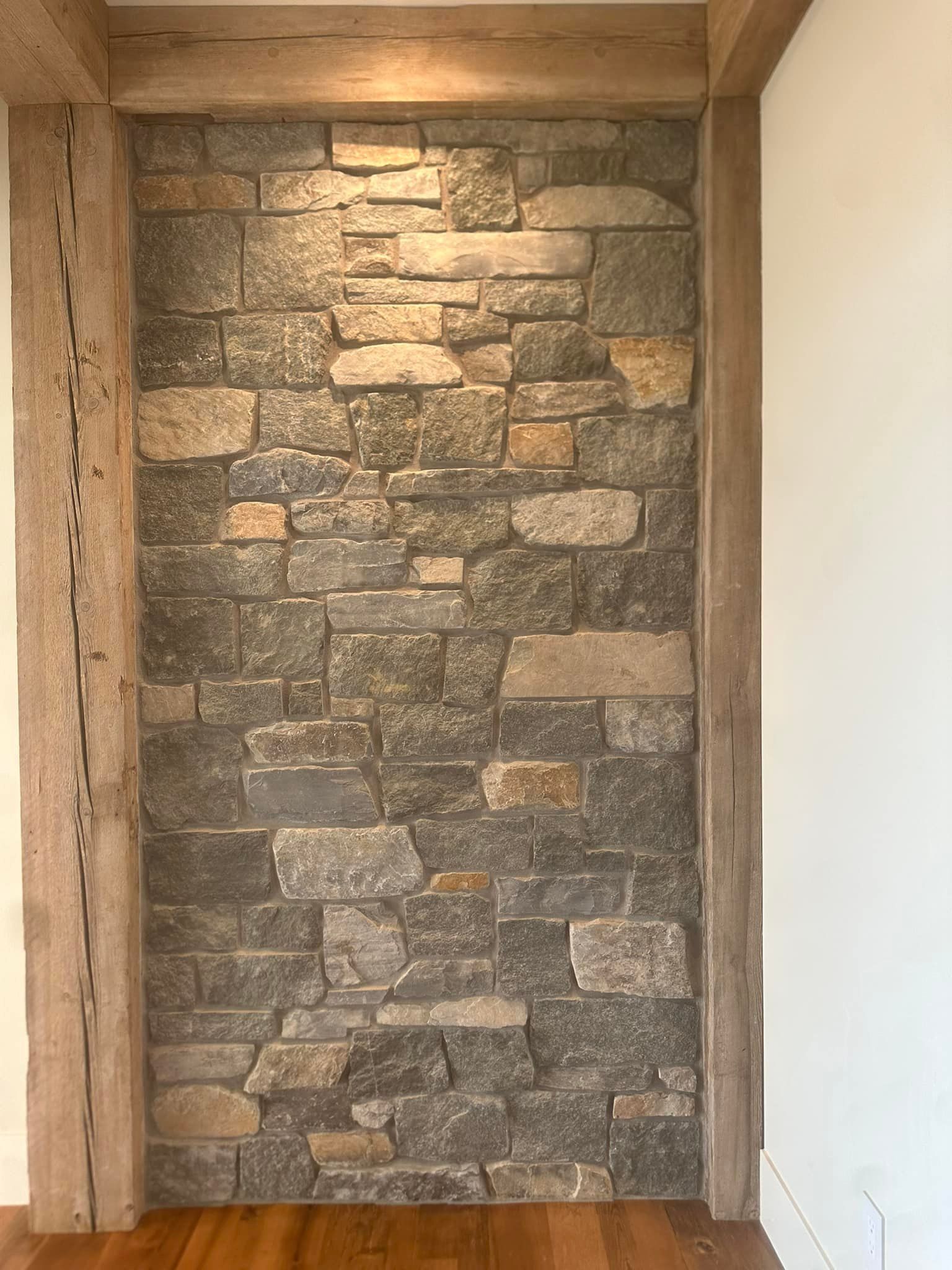 A stone wall with wooden beams in a room.