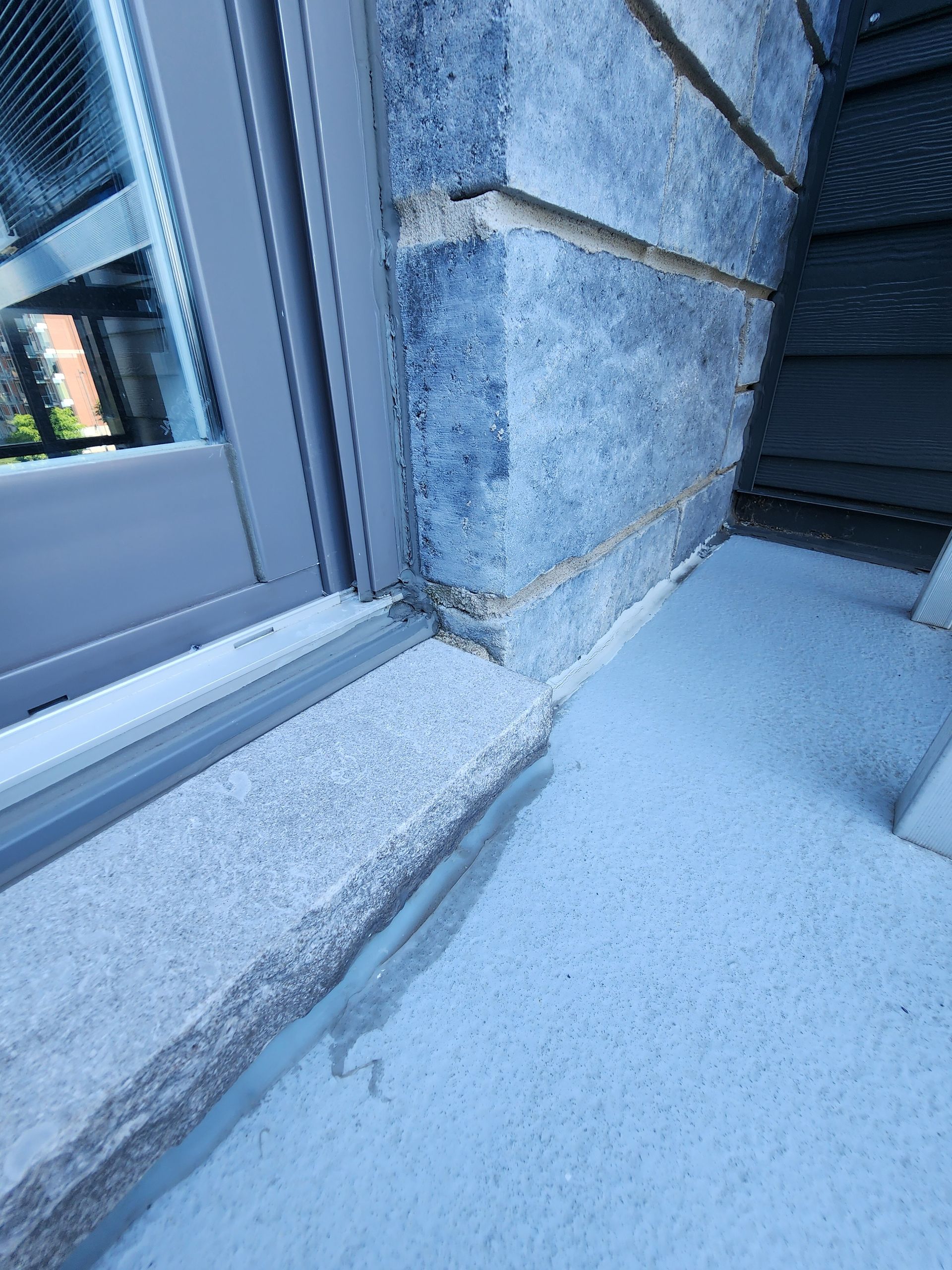 Un gros plan d'un rebord de fenêtre sur un mur de briques.