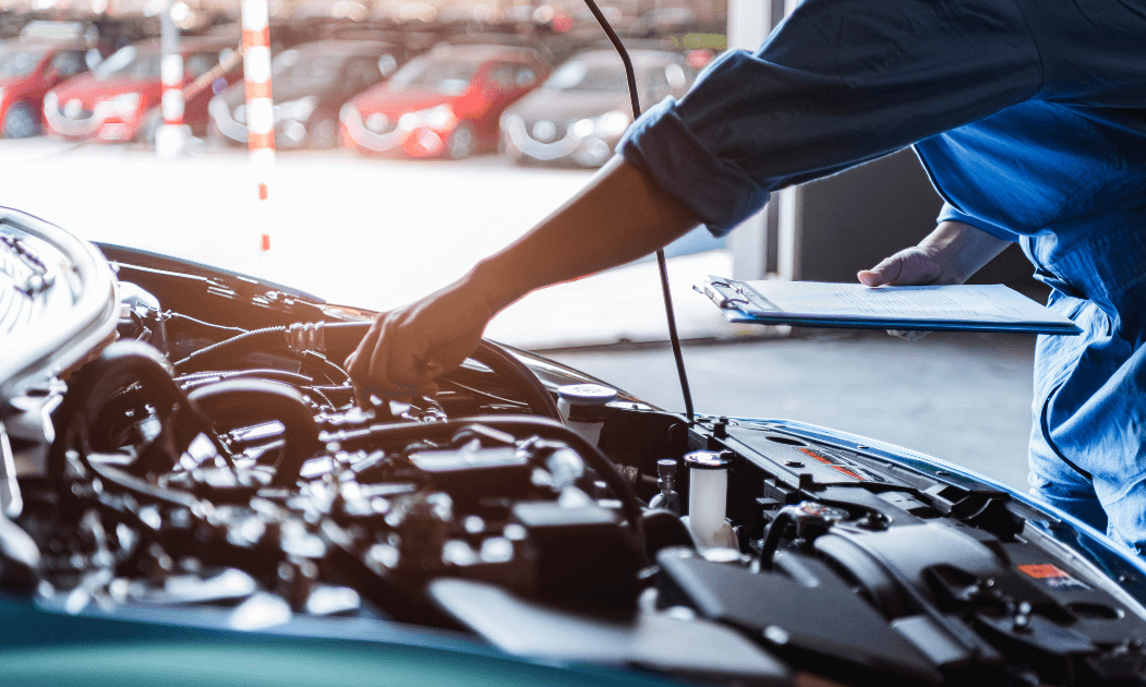 Mechanic under the hood of a car during the day in Concord, NC