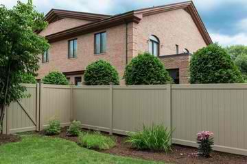 A brick house with a tan fence in front of it.