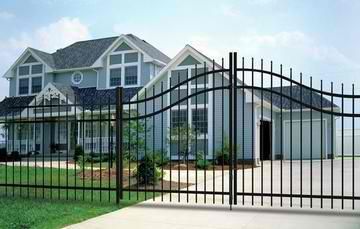 A large house with a wrought iron gate in front of it.