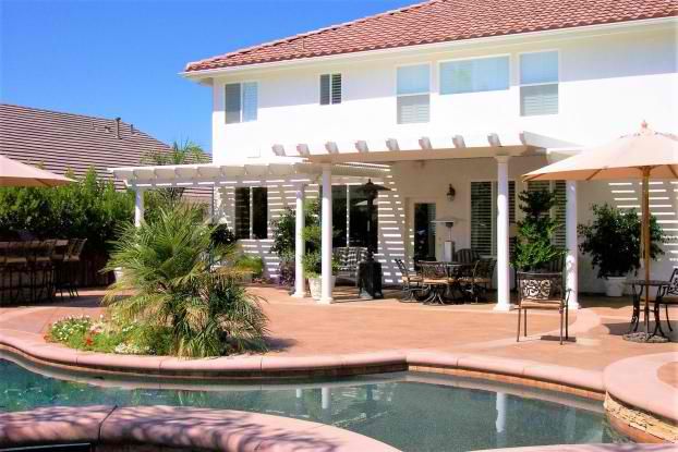 A large white house with a swimming pool in front of it