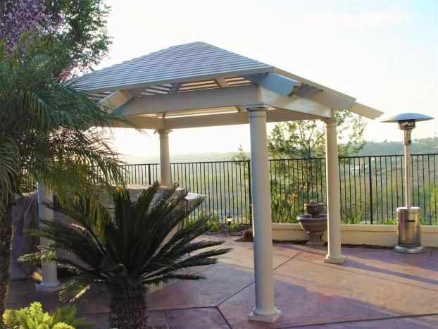 A gazebo is surrounded by palm trees and a fence