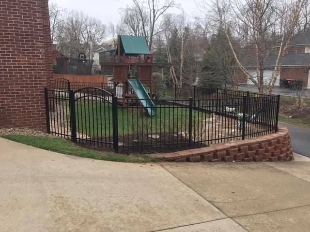 There is a playground in the backyard behind a fence.