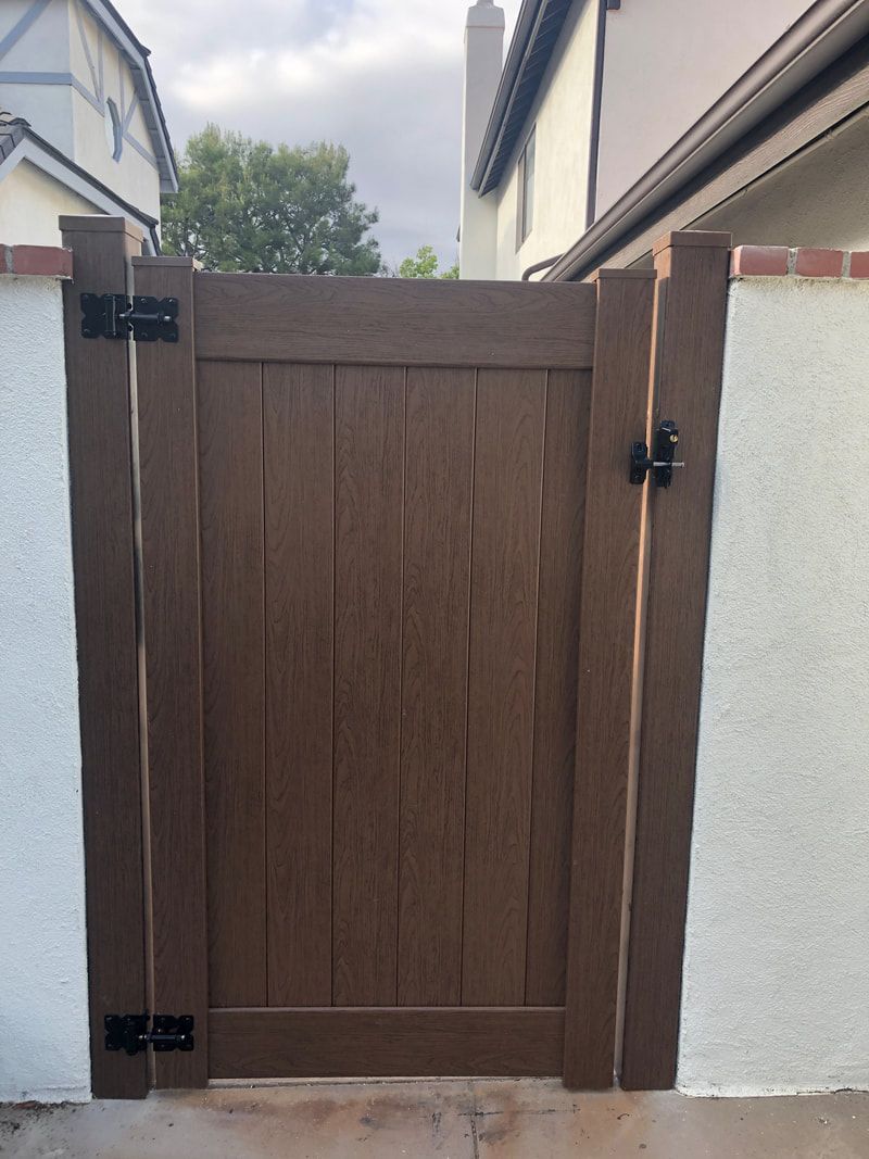 A wooden gate is sitting in front of a white wall.