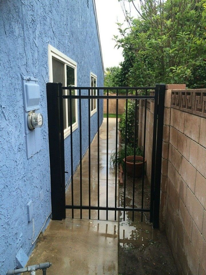 A blue building with a black gate in front of it