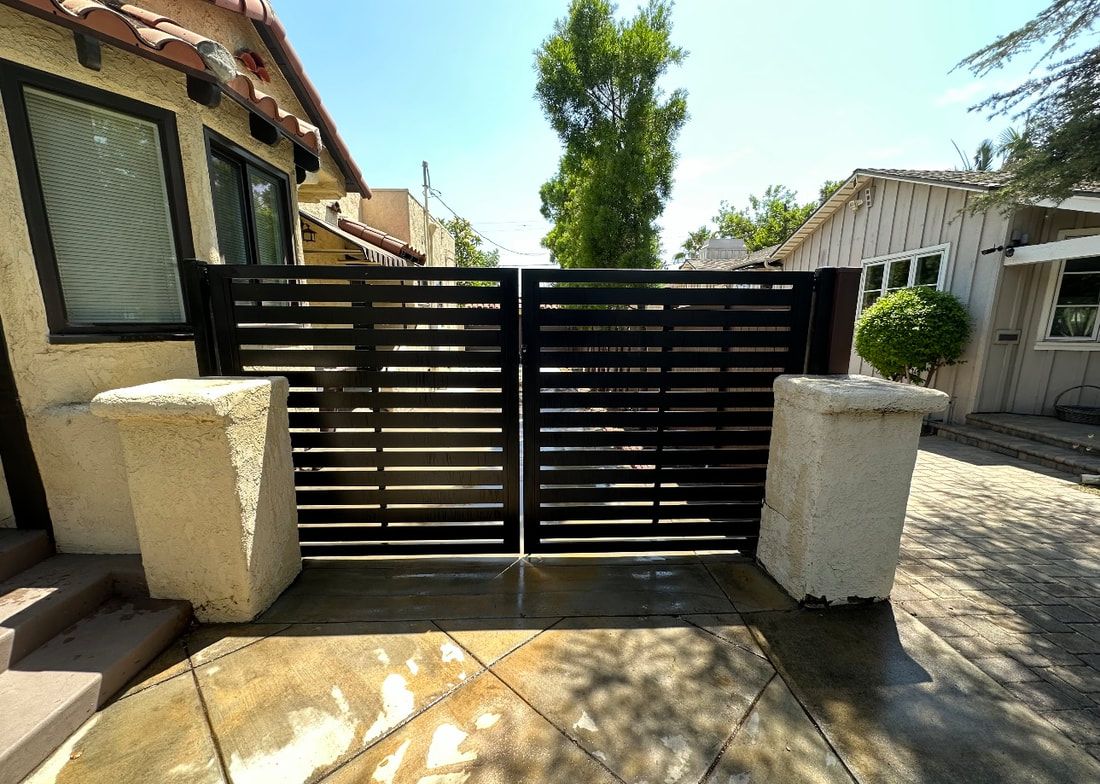 A black gate is sitting in front of a house.