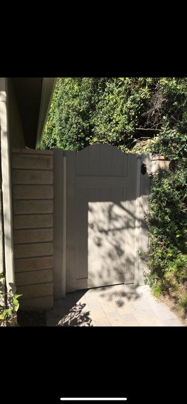 A shadow of a person is cast on a wall next to a house.