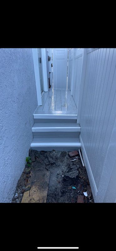A set of stairs leading up to a white fence.